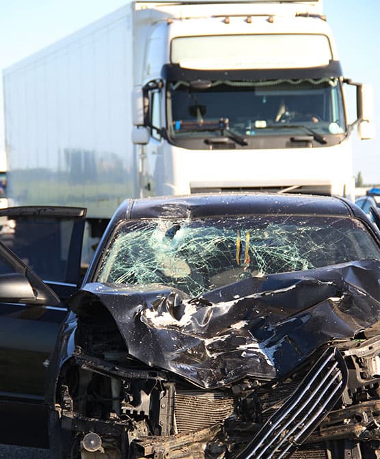 Fotografía de un auto destrozado en un accidente de camión.