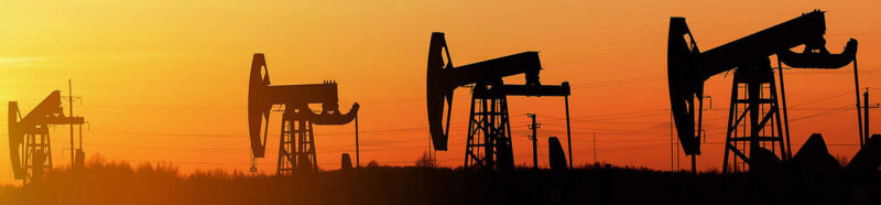 Fotografíagrafía de plataformas de perforación de petróleo al atardecer, relacionada con accidentes en campos petrolíferos.