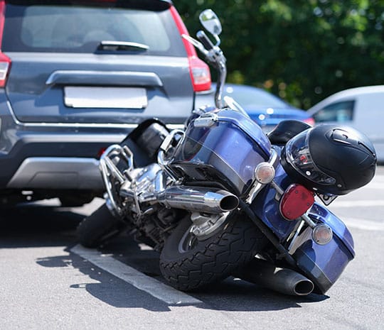 Fotografíagrafía de un accidente de motocicleta con un auto.