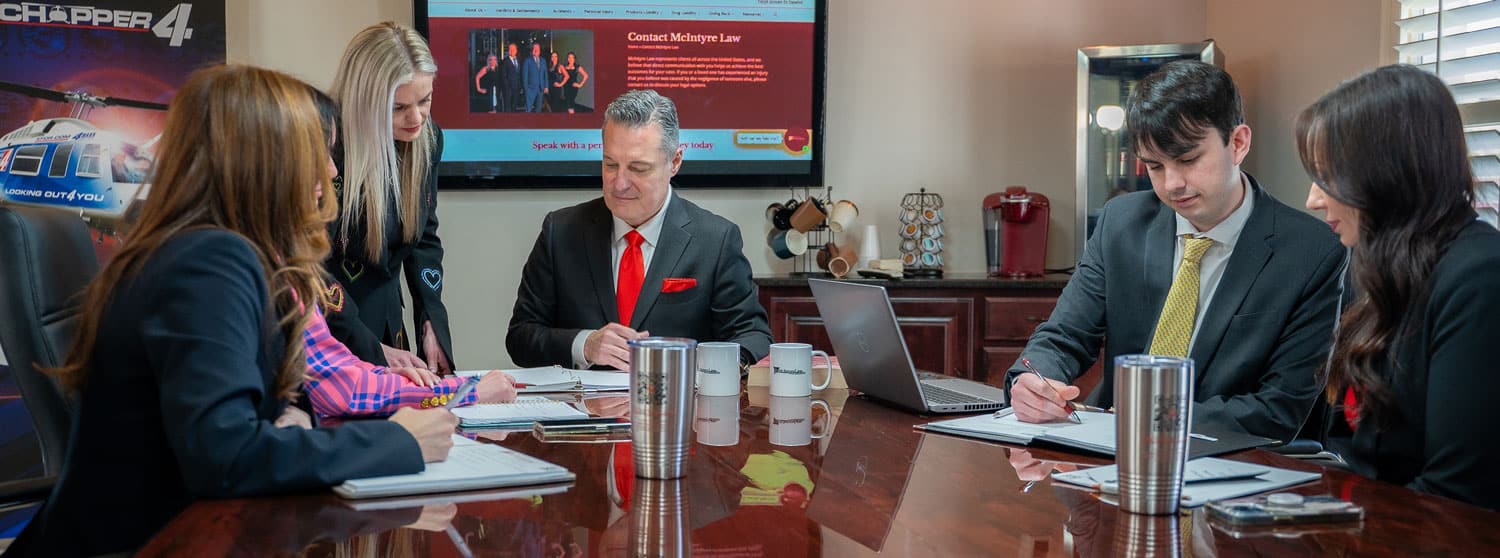 Fotografía del equipo de McIntyre Law Firm discutiendo un caso.