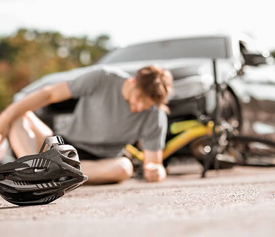 Fotografíagrafía de un ciclista tendido en la calle tras un accidente de bicicleta.