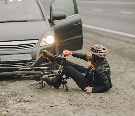 Fotografíagrafía de una mujer herida tras un accidente de bicicleta con un auto.